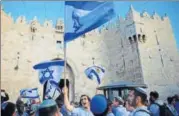  ?? AP FILE ?? ▪ Israelis wave national flags outside the Damascus Gate in Jerusalem’s Old City.