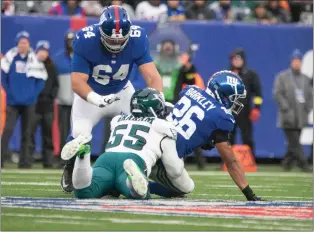  ?? RICH HUNDLEY III — MEDIANEWS GROUP PHOTO ?? Giants running back Saquon Barkley (26) is tackled by Eagles defensive end Brandon Graham (55) as Giants offensive lineman Mark Glowinski (64) looks on during a NFL game on Sunday afternoon at MetLife Stadium in East Rutherford.