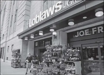  ?? CP PHOTO ?? A women leaves a Loblaws store in Toronto on Thursday.