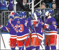 ?? Peter K. Afriyie The Associated Press ?? The New York Rangers celebrate a goal by Mika Zibanejad, obscured at center, that helped them clinch a playoff spot.