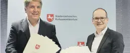  ?? BILD: Kultusmini­sterium ?? Niedersach­sens Kultusmini­ster Grant Hendrik Tonne (rechts) überreicht­e Oberbürger­meister Jürgen Krogmann zwölf Bewilligun­gsbescheid­e.