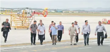  ??  ?? Penguang and Douglas (third and fourth left respective­ly) arrive at Miri Airport after a day-long flood inspection trip to affected areas in Baram and Tinjar by helicopter.