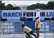  ?? (AP/Alex Brandon) ?? Workers set up for the March for Our Lives rally on the National Mall on Friday in Washington. The march is returning to Washington after four years.