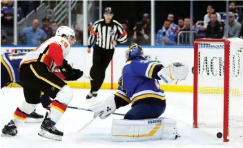  ?? JEFF ROBERSON/ THE ASSOCIATED PRESS ?? Flames forward Matthew Tkachuk scores his first goal in his hometown against Blues goaltender Jake Allen on Sunday in St. Louis. The Flames were 7-2 winners, their eighth win in nine.