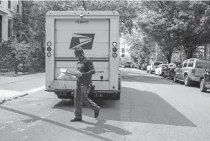  ?? CALLA KESSLER/WASHINGTON POST ?? A postal worker delivers packages earlier this month in the Brooklyn borough of New York.