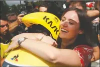  ?? The Associated Press ?? REWARDED: Geraint Thomas, wearing the overall leader’s yellow jersey left, hugs his wife, Sarah Elen, Saturday after the 20th stage of the Tour de France.