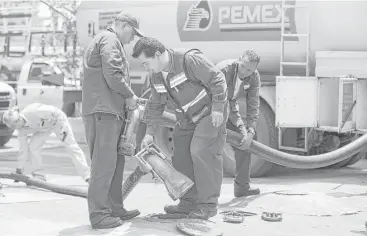  ?? Susana Gonzalez / Bloomberg file ?? Workers move fuel lines from a tanker truck at a Pemex station in Mexico City. Petroleos Mexicanos was among eight companies cited in a study whose fuel was responsibl­e for a third of emissions from oil and gas.