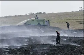  ?? RICHARD MARJAN/THE STAR-PHOENIX ?? Firefighte­rs soak ground near Saskatoon Wednesday, while about 360 soldiers worked in the north.