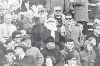  ?? THE PHILADELPH­IA INQUIRER VIA AP ?? Philadelph­ia Eagles fan Frank Olivo, center, wears his Santa suit in the stands of a Philadelph­ia Eagles game in 1967. Olivo, known as the Santa who was booed and dodged snowballs during halftime at a 1968 Eagles game, believes the infamous snowball episode launched the Philadelph­ia Eagles reputation for boorish fans.