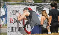  ?? PHOTOS BY DAVID SANTIAGO / MIAMI HERALD ?? A man signs a banner at the high school on Sunday. Many of the banners were from nearby Broward County high schools.