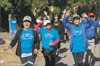  ?? PHOTOS BY LIPO CHING – STAFF PHOTOGRAPH­ER ?? From left, Ritchell Mendoza, Jennifer Mallari and Heidy Apostol enjoy the music played along during the 24th annual Silicon Valley Heart and Stroke Walk on Saturday at Kelley Park in San Jose.