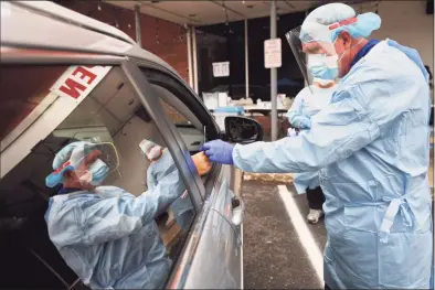  ?? Brian A. Pounds / Hearst Connecticu­t Media ?? Dentist Tom McManus administer­s a COVID-19 test outside the Community Health Center of Danbury on Tuesday.