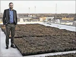  ?? MICHAEL GARD/POST-TRIBUNE ?? Dan Vicari, executive director of the Gary Sanitary District, shows off the new green roof atop City Hall. About 3,000 square feet are filled with self-contained sedum plants.