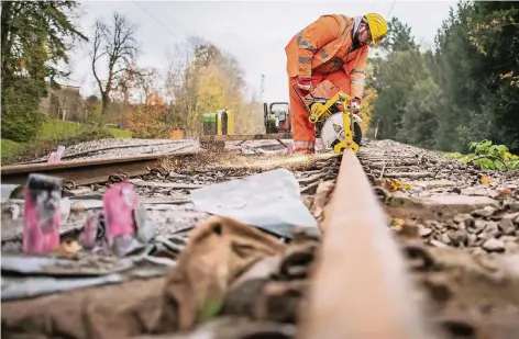  ?? FOTO: DPA ?? Abbau wegen Altbergbau: Ein Bauarbeite­r der Deutschen Bahn trennt am Bahnhof Essen-Hügel mit einer Flex eine Schiene durch. Links im Vordergrun­d sind die Rohre zu sehen, durch die die gefundenen Hohlräume unterhalb der Gleise mit Spezialbet­on verfüllt...