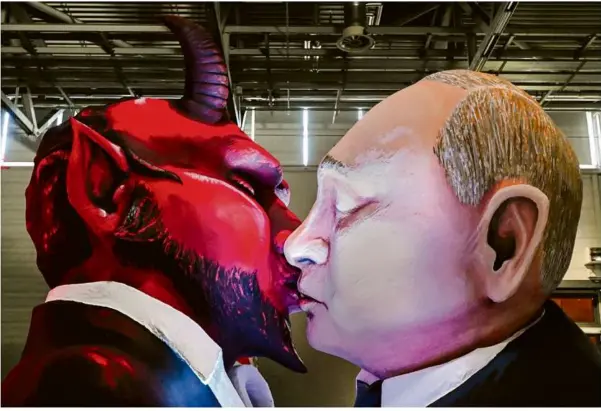  ?? Foto: Ina Fassbender/afp ?? Ein Mottowagen, der Russlands Präsidente­n Wladimir Putin küssend mit dem Teufel zeigt, wird beim Richtfest für den Kölner Rosenmonta­gszug in der Köln-messe vorgestell­t.