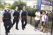  ?? M. Spencer Green / Associated Press ?? Chicago Police patrol the neighborho­od as Crystal Stoval delivers her niece Kayla Porter from their south side home to Gresham Elementary School on the first day of classes in August 2013 in Chicago. Chicago Public Schools closed about 50 schools and programs that year.