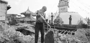  ??  ?? A labourer work to demolish a monastery damaged during the 2015 earthquake, in Swayambhun­ath Stupa, a UNESCO world heritage site in Kathmandu, Nepal. — Reuters photo