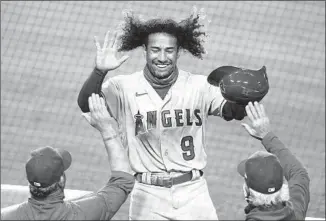  ?? Ashley Landis Associated Press ?? THE ANGELS’ Jahmai Jones gets a hero’s welcome after scoring on a triple by Jared Walsh during the third inning on Saturday night. The Angels rallied to take a 4-3 lead in the inning.