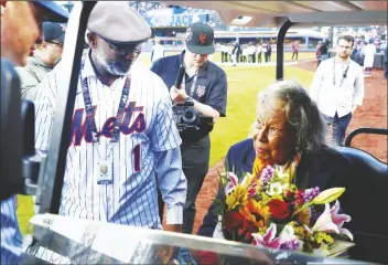  ?? NOAH K. MURRAY/AP ?? FORMER NEW YORK METS MOOKIE WILSON (LEFT) PRESENTS RACHEL ROBINSON with flowers in honor of Jackie Robinson Day before a game between the Mets and the Pittsburgh Pirates on Monday in New York.