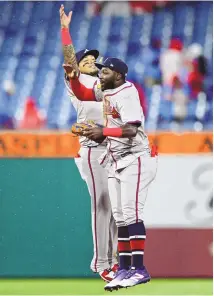  ?? DERIK HAMILTON / ASSOCIATED PRESS ?? Atlanta’s Orlando Arcia, left, and Michael Harris II celebrate a 12-4 Braves win over the Philadelph­ia Phillies on Saturday in Philadelph­ia.