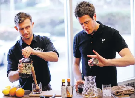  ??  ?? Kyle Guilfoyle, left, and Nate Caudle make an old fashioned two ways, traditiona­l and streamline­d. The drink dates back to the 1800s.
