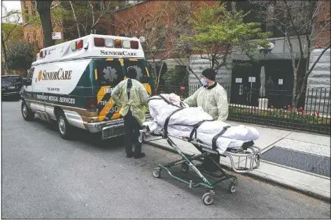  ?? (File Photo/AP/John Minchillo) ?? A patient is wheeled out of Cobble Hill Health Center by emergency medical workers in the Brooklyn borough of New York.