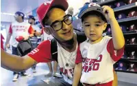  ?? D.A. VARELA dvarela@miamiheral­d.com ?? Puerto Rico fan Luis Roman, 32, and his son Aiden, 2, try on hats at the team store before the start of the game.