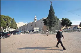  ??  ?? A man walks outside the Church of the Nativity in the West Bank City of Bethlehem, on Nov. 23. Missing are the thousands of internatio­nal pilgrims who normally descend upon the town.