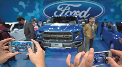  ?? MARK SCHIEFELBE­IN/AP ?? Ford said its net income dropped 56 percent to $957 million in the third quarter.