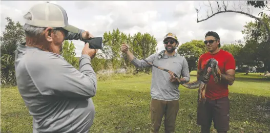  ?? PHOTOS: CINDY KARP/FOR THE WASHINGTON POST ?? `Captain' Bud takes a photo of Zack Parisa and writer Michael Coren as they show off the day's catch.