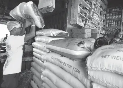  ?? SUNSTAR FILE ?? PILING ON THE KILOS. A laborer piles sacks of rice in a retail store in Carbon Market. Respondent­s of a Pulse Asia survey say the most urgent concern the government should address is giving Filipinos higher wages.