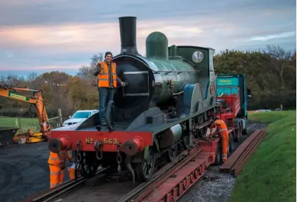  ?? NATHAN AU ?? Swanage railway Trustee matt mcmanus (standing on the ‘T3’s’ running plate) waves goodbye to No. 563 as the former National Collection 4-4-0 is winched onto a low-loader for its move to the Flour mill workshops on November 13.