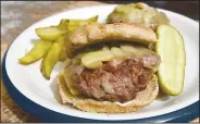  ?? NWA Democrat-Gazette/FLIP PUTTHOFF ?? A mushroom and Swiss venison burger is a Camp See No Deer favorite. It’s delicious with or without the toasted bun. Served with grilled steak fries and a crisp dill pickle, it’s a meal that’ll satisfy any hungry hunter.