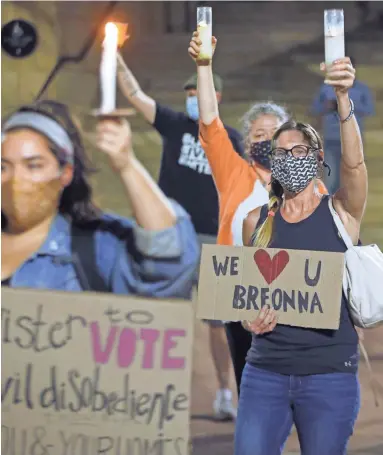  ?? PATRICK BREEN/THE REPUBLIC ?? People gather during a vigil for Dion Johnson and Breonna Taylor in Phoenix on Thursday.