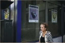  ?? (Alkis Konstantin­idis) ?? A WOMAN walks past a bank branch advertisin­g debit cards in Athens on Tuesday. Greece lags far behind other EU countries in noncash transactio­ns. But Greeks have suddenly fallen in love with payment by plastic after capital controls were imposed in...