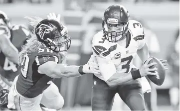  ?? - AFP photo ?? Brooks Reed #50 of the Atlanta Falcons tries to tackle Russell Wilson #3 of the Seattle Seahawks at the Georgia Dome in Atlanta, Georgia. - Seattle Seahawks quarterbac­k RussellWil­son is to become the highest-paid player in the NFL after agreeing a four-year contract extension worth $140 million, reports said April 16, 2019. Wilson appeared to confirm the reports with a video message on Twitter.