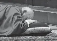  ?? Pool / AFP via Getty Images ?? Pope Francis lies down in prayer prior to a celebratio­n for Good Friday at St. Peter’s Basilica in the Vatican.