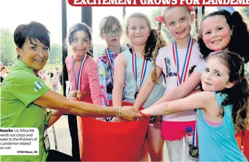  ??  ?? Snacks Liz Arbuckle hands out crisps and water to the finishers of a Landemer-related fun run