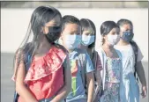  ?? DENIS POROY — THE ASSOCIATED PRESS ?? Masked students wait to be taken to their classrooms at Enrique S. Camarena Elementary School in Chula Vista.