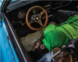  ?? MERIDITH KOHUT/THE NEW YORK TIMES ?? A motorist in Caracas caught a few winks as he joined more than 80 drivers lined up overnight to buy a battery from the limited supply the next day.