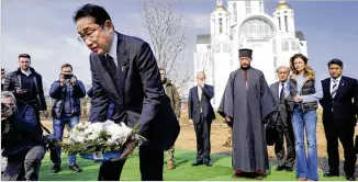  ?? Outside Kyiv that became IORI SAGISAWA/KYODO NEWS VIA AP ?? Japanese Prime Minister Fumio Kishida lays flowers at a church in Bucha, a town a symbol of Russian atrocities against civilians, in Ukraine on Tuesday.