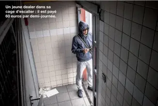  ??  ?? Un jeune dealer dans sa cage d’escalier : il est payé 60 euros par demi-journée.