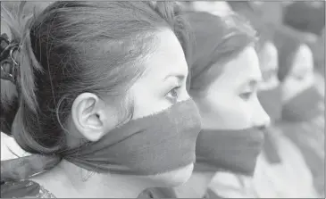  ??  ?? ASSOCIATED PRESS Photojourn­alists in Gauhati, India, with black bands around their mouth, protest against the gang rape of a photojourn­alist in Mumbai that has enraged the country. Press groups called for protection for women journalist­s working in the...