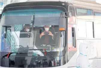  ?? REUTERS ?? Members of the World Health Organizati­on team tasked with investigat­ing the origins of the virus on a bus before leaving Wuhan Tianhe Internatio­nal Airport in Wuhan.