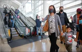  ?? NHAT V. MEYER — BAY AREA NEWS GROUP ?? Travelers wear masks while heading to baggage claim at the Norman Y. Mineta San Jose Internatio­nal Airport in San Jose on Wednesday. The CDC extended the travel mask mandate for another 15 days.