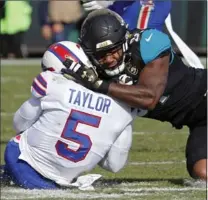  ?? STEPHEN B. MORTON, THE ASSOCIATED PRESS ?? Jaguars defensive end Yannick Ngakoue, right, drew a penalty for hitting Bills QB Tyrod Taylor with helmet-to-helmet contact. Jags won, 10-3.