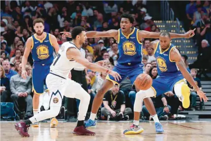  ??  ?? Golden State Warriors’ Klay Thompson (11) looks on as Damian Jones (15) and Andre Iguodala (9) defend against Denver Nuggets’ Jamal Murray in the fourth quarter at the Pepsi Center. — USA Today Sports