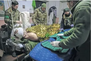  ?? ?? Médicos dan primeros auxilios a un soldado ucraniano herido cerca de Bakhmut, en la región de Donetsk.