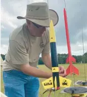  ?? JOE MARIO PEDERSEN/ORLANDO SENTINEL ?? Rick Cody, 54, of Orlando, prepares his model rocket in the middle of a field at Little Big Econ State Forest on Aug. 8, during an event organized by Central Florida’s ROCK model rocket club.