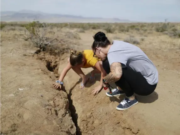  ??  ?? California­ns inspect a rupture in Ridgecrest two weeks ago (Getty)